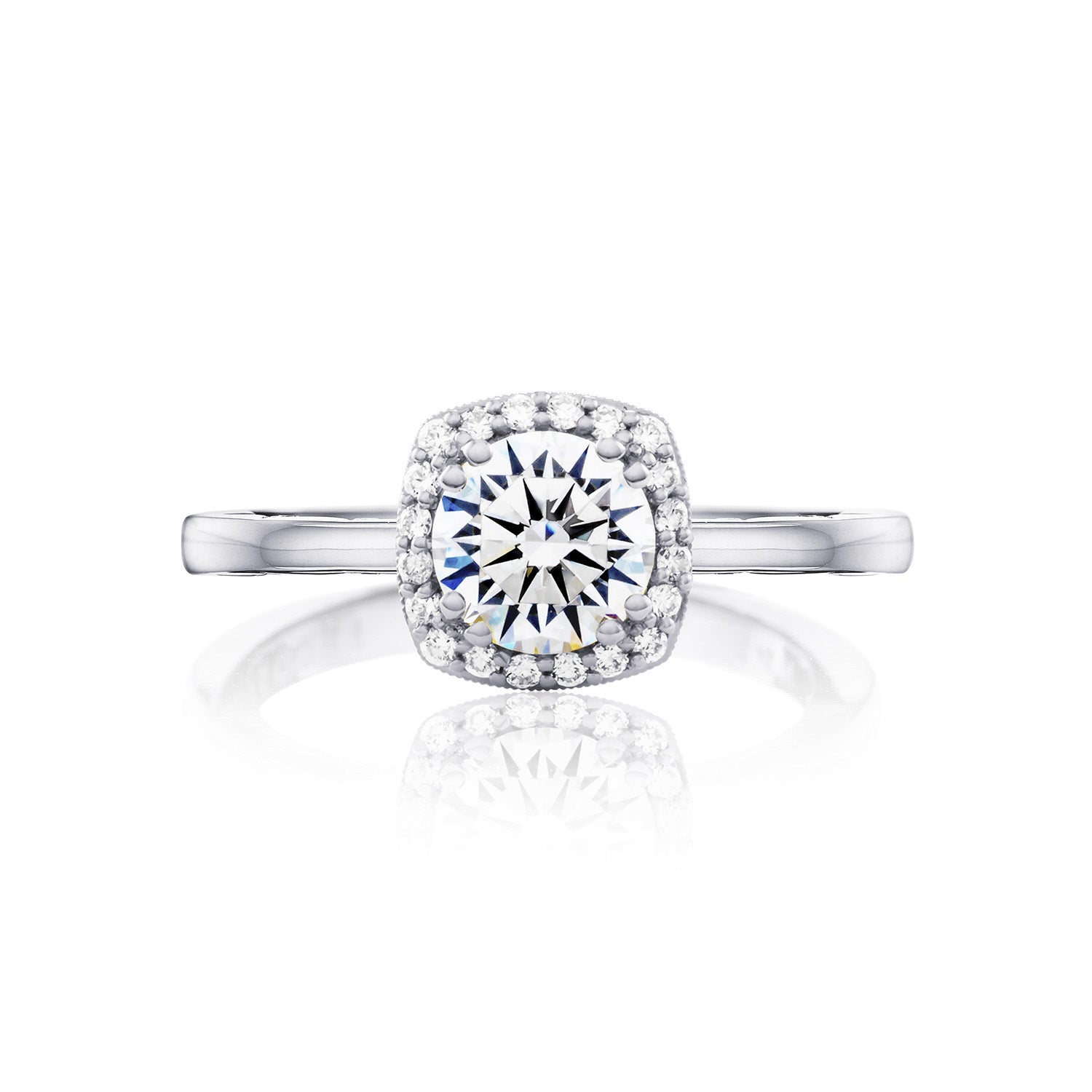 A close-up of the Tacori Coastal Crescent 14K White Gold Round Brilliant Semi Mount Engagement Ring, showcasing a large round diamond at its center surrounded by a halo of smaller diamonds. The ring features a sleek, polished band with diamond accents that beautifully reflect light, all set against a plain white background.