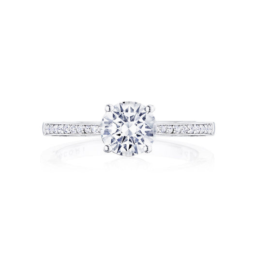 The Tacori Coastal Crescent 14K White Gold Round Brilliant Solitaire Semi Mount with Diamond Band Engagement Ring showcases a large round diamond at its center, complemented by smaller diamonds along the band. This exquisite piece from Tacori is beautifully displayed against a plain white background.