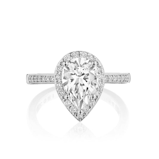 The Tacori Coastal Crescent 14K White Gold Pear Semi Mount with Diamond Band and Halo Engagement Ring features a stunning pear-shaped diamond center encircled by round-brilliant diamonds. The band, embellished with more small diamonds, enhances its brilliance against the white gold setting, highlighting the expert craftsmanship of Tacori gemologists.