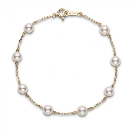 The Mikimoto 18K Yellow Gold Akoya Cultured Pearl Station Bracelet from the renowned brand Mikimoto showcases exquisite white Akoya cultured pearls that are gracefully distributed along a slim 18k yellow gold chain, secured with a simple clasp. Its elegant and minimalist design emphasizes the lustrous beauty of the pearls.