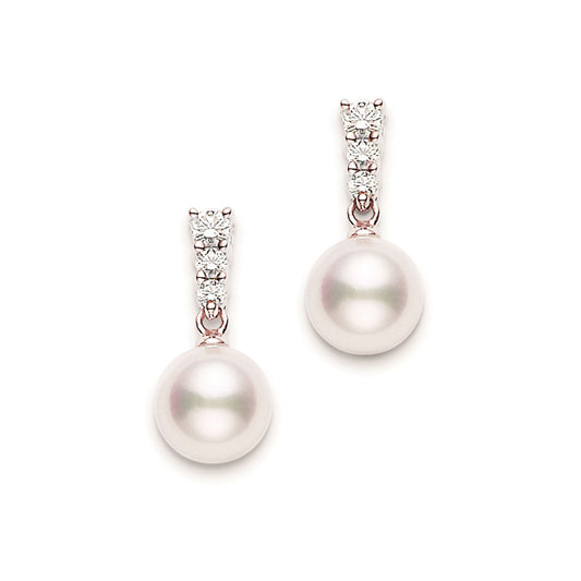 The Mikimoto Morning Dew 18K Rose Gold Diamonds with Akoya Cultured Pearl Drop Earrings showcase elegant, large, round cultured pearls. Each pearl is elegantly suspended from a vertical trio of sparkling diamonds set in a metallic mount, presenting a design that is both simple and sophisticated.