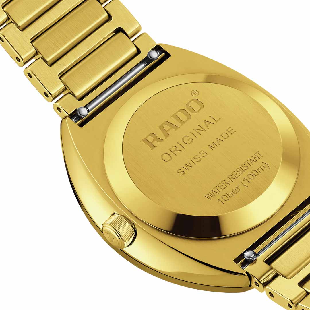 Close-up image of the back of a yellow gold-coloured RADO DiaStar Original Automatic 38mm watch featuring a metal bracelet. The watch is engraved with "RADO DiaStar Original, SWISS MADE" and offers an automatic movement along with water resistance up to 10 bar (100m).