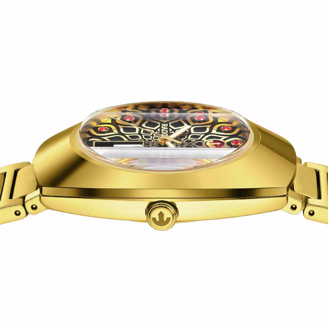 View of a RADO DiaStar Original Automatic 38mm Watch in yellow gold, showcasing its side profile with a crown on the side. The detailed dial presents a geometric pattern with red and gold accents on a black background, highlighting the elegance of its automatic movement. The watch is completed with an elegant gold metal strap.