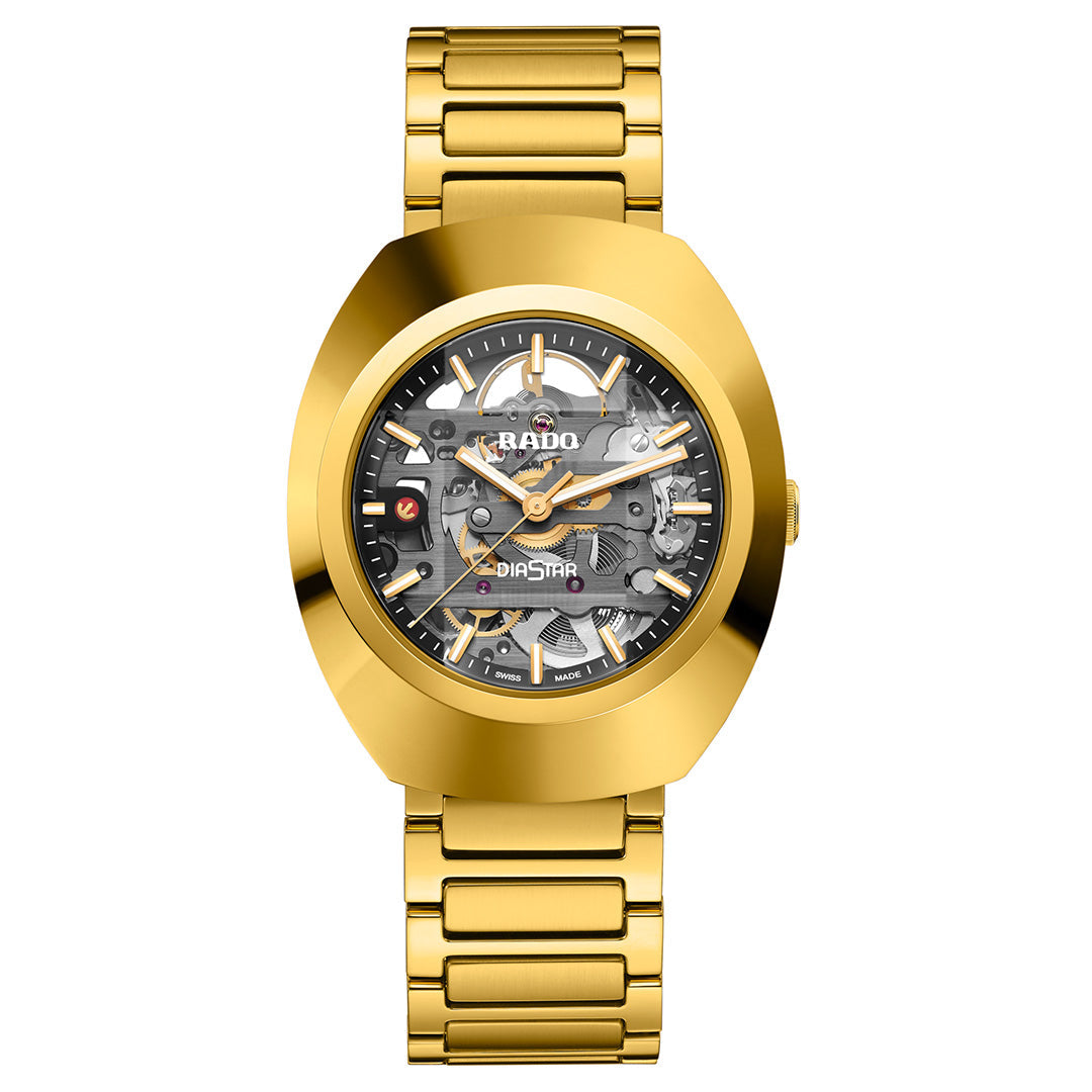 The RADO DiaStar Original Skeleton Automatic 38mm Watch features a gold Ceramos bezel, skeleton dial with visible gears, bold gold hour markers, and a matching gold metal link band.