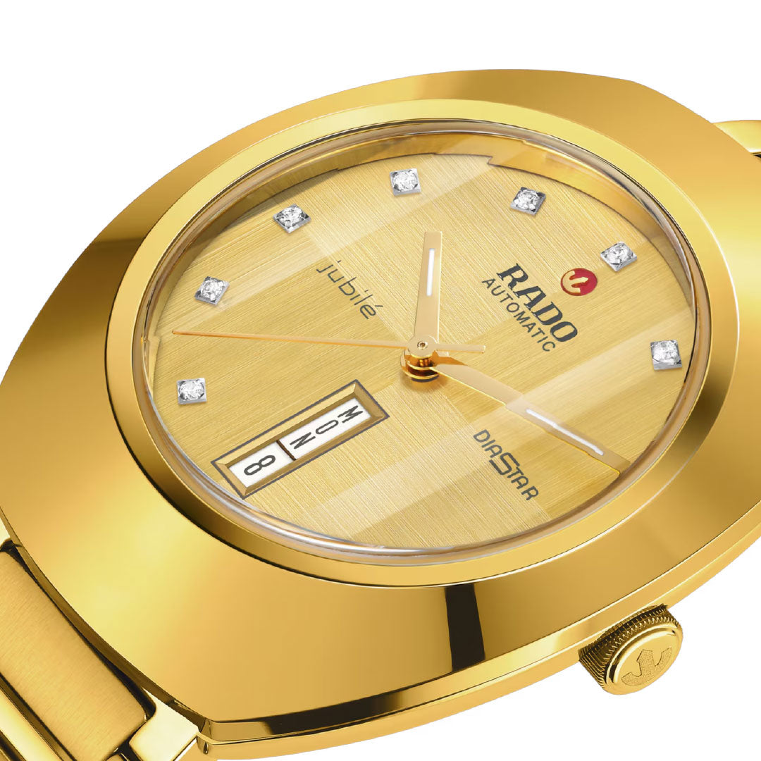 Close-up of the RADO DiaStar Original Automatic 38mm watch, featuring a diamond dial, day-date at 6 o’clock, and polished gold bracelet. The RADO logo is clearly visible on the dial.