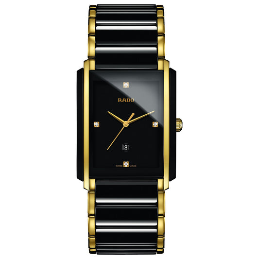 The RADO Integral Diamonds Quartz 31mm x 41.1mm watch boasts a sleek rectangular design with a black face accented by luxurious gold details. It features gold hour and minute hands, four small square markers, and a date display at the bottom. Enhancing its elegance is the two-tone bracelet crafted from high-tech ceramic in gold and black, perfectly complemented by the distinguished "RADO Integral" name.