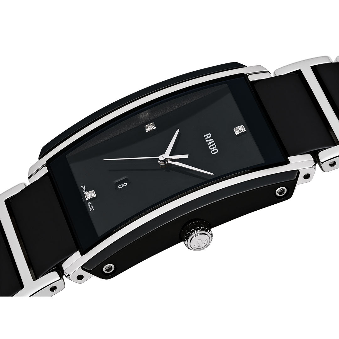 A close-up of the RADO Intergal Diamonds Quartz 31mm Watch, featuring a curved rectangular black dial with diamond markers, silver hands, and a black high-tech ceramic and silver band. The crown displays the RADO logo.