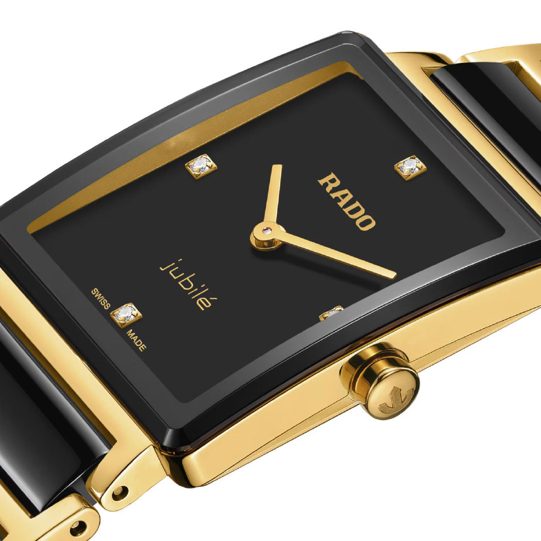 Close-up of the RADO Integral Diamonds Quartz 23mm Watch, featuring a rectangular black dial with four diamond markers, a high-tech ceramic and yellow gold-tone case, and a glossy two-tone black and gold bracelet.