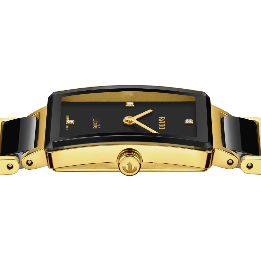 A close-up side view of the RADO Integral Diamonds Quartz 23mm Watch showcases its rectangular face, diamond hour markers, yellow gold hands, curved design, crown, and high-tech ceramic details.