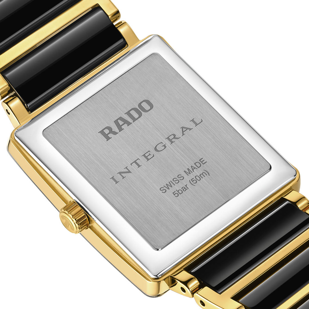 Close-up of the RADO Integral Quartz 31.5mm Watch’s back, highlighting its rectangular stainless steel case with gold-tone edges, black ceramic links, and engraved "RADO INTEGRAL SWISS MADE 5 bar (50m)".