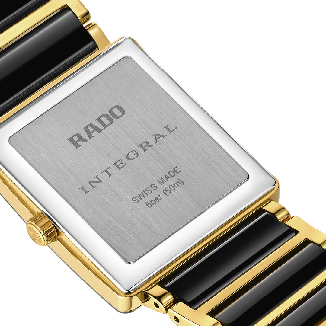Close-up of the RADO Integral Diamonds Quartz 31.5mm Watch shows its rectangular stainless steel and yellow gold case, sapphire crystal, and black ceramic and gold bracelet. The back is engraved "RADO INTEGRAL SWISS MADE 5 bar (50m)".