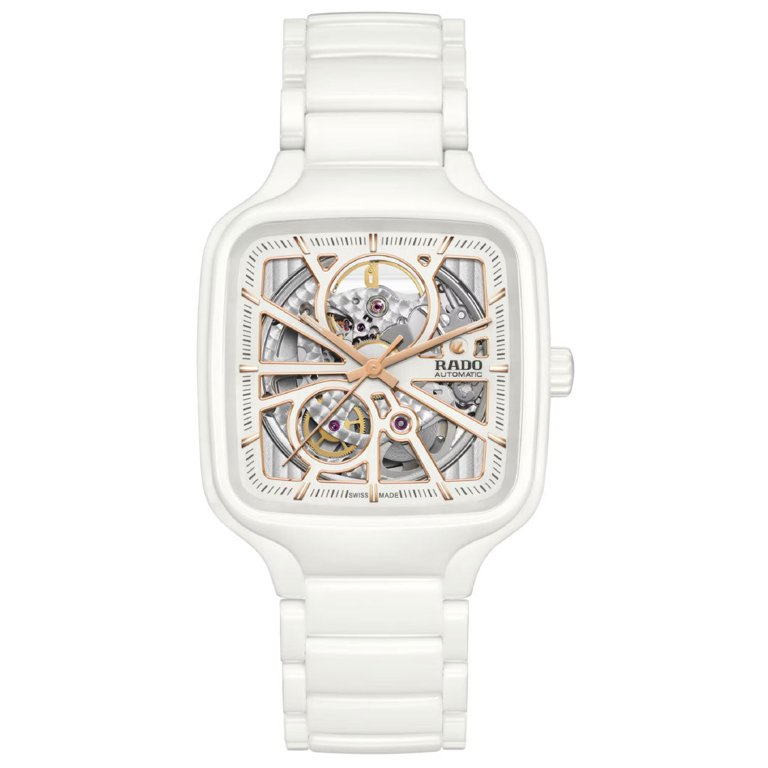 The RADO True Square Automatic Open Heart 38mm watch features a white high-tech ceramic case, square face, exposed skeleton dial with gold-tone details, showcasing inner gears and the "RADO" logo on the right.