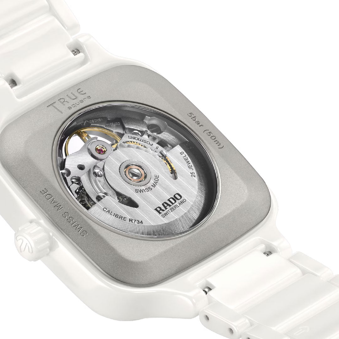 Close-up of the RADO True Square Automatic Open Heart 38mm Watch, featuring a transparent case back that reveals the intricate mechanical movement, visible gears, and engraved metal details.