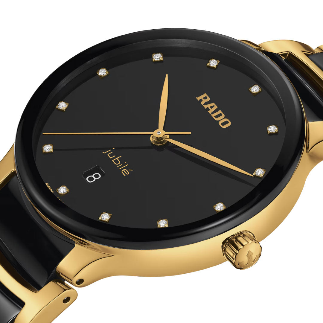 Close-up of the RADO Centrix Diamonds Quartz 39.5mm watch with a yellow gold PVD stainless steel case, black sunray dial, gold hands, diamond hour markers, date at 6 o’clock, crown, and a gold-and-black band visible.