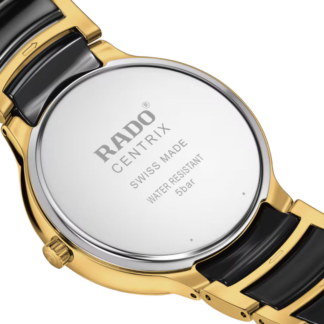 Close-up of the RADO Centrix Diamonds Quartz 39.5mm Watch back, showing its yellow gold PVD-coated stainless steel and black ceramic bracelet, engraved with "RADO CENTRIX SWISS MADE WATER RESISTANT 5 bar.