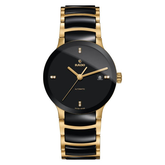 The RADO Centrix Automatic 38mm Watch embodies sophistication with its black dial and gold-tone markers. It boasts a sapphire crystal and a date display at the 3 o'clock position, complemented by an elegant gold and black metal bracelet. This timepiece is proudly "Swiss Made.