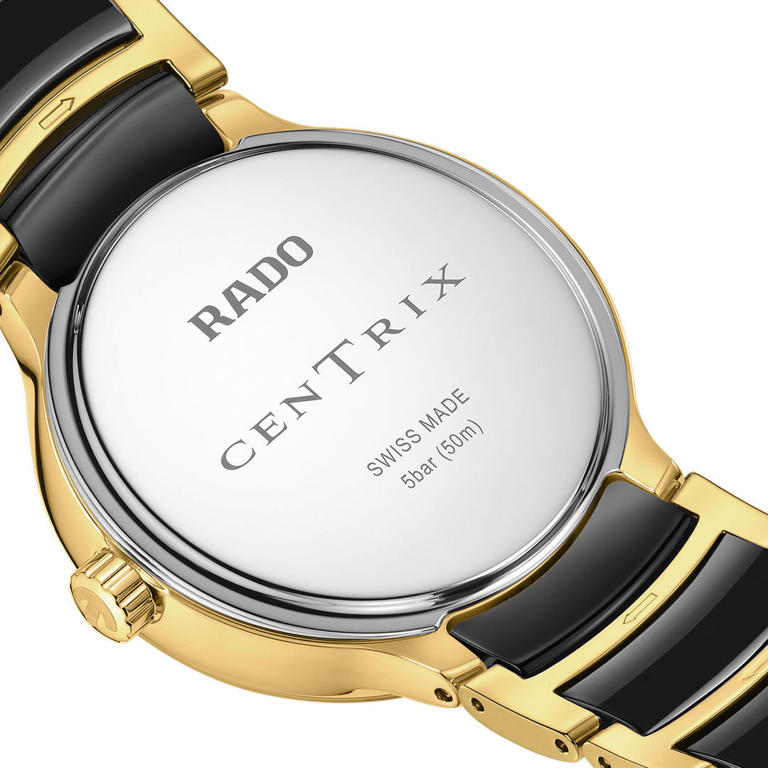 Close-up of the RADO Centrix Moonphase Quartz 35mm watch back, showing a silver case labeled "RADO Centrix Swiss Made 5 bar (50m)" and a gold and black high-tech ceramic bracelet.