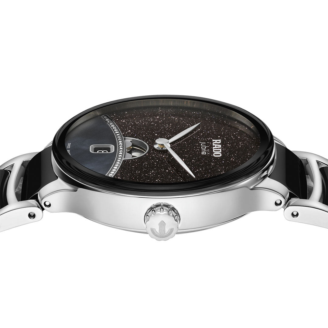 A close-up side view of the RADO Centrix Moonphase Quartz 35mm Watch shows its sparkling black dial, silver hands, date window, polished metal case and bracelet with high-tech ceramic accents, and a prominent engraved crown.