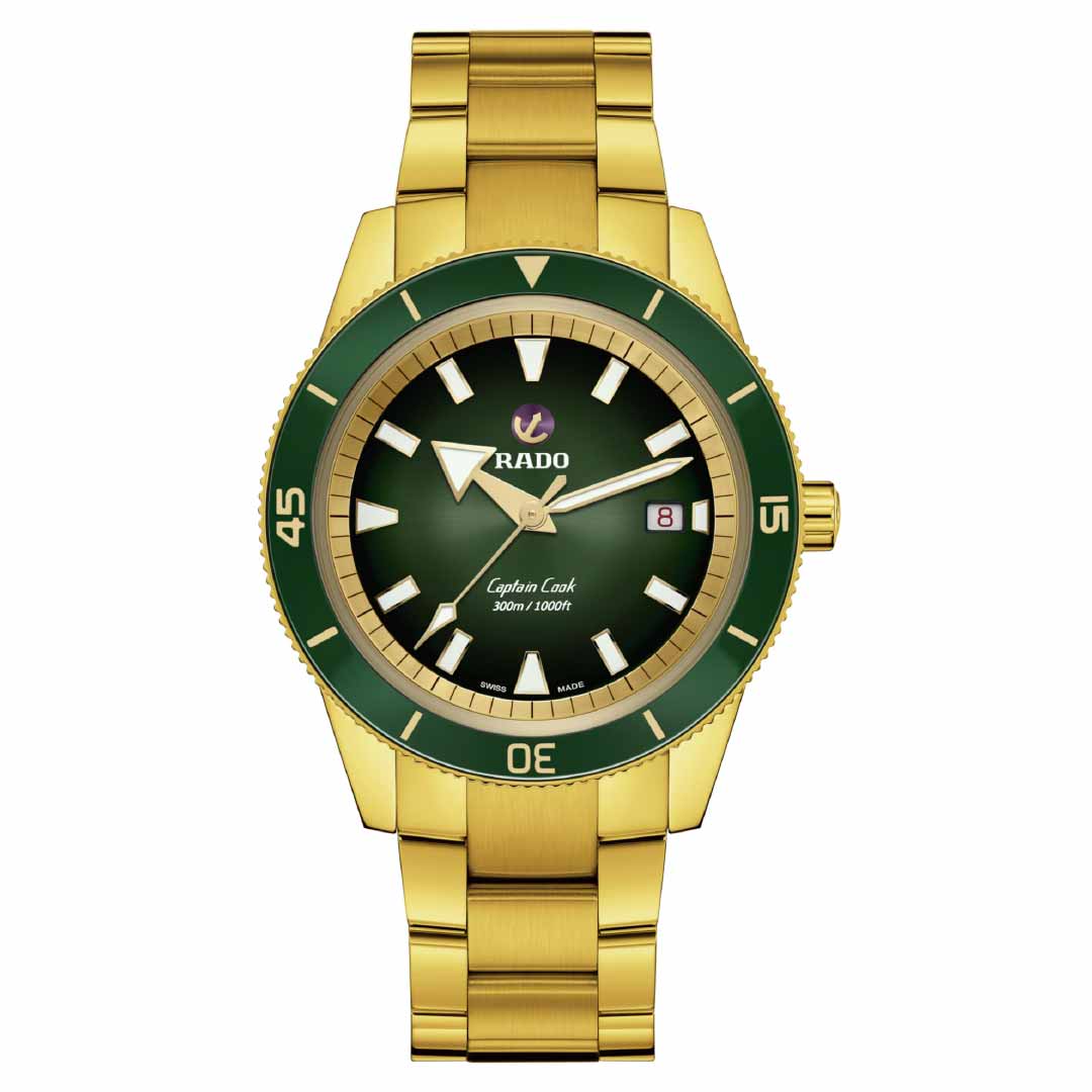 The RADO Captain Cook Automatic 42mm Watch features a gold case complemented by a striking green bezel and dial. It includes white hour markers, gold hands, and a small date display at the 3 o'clock position, with the iconic RADO brand logo on the dial. This watch is equipped with automatic movement and is water-resistant, paired elegantly with its metal link bracelet.