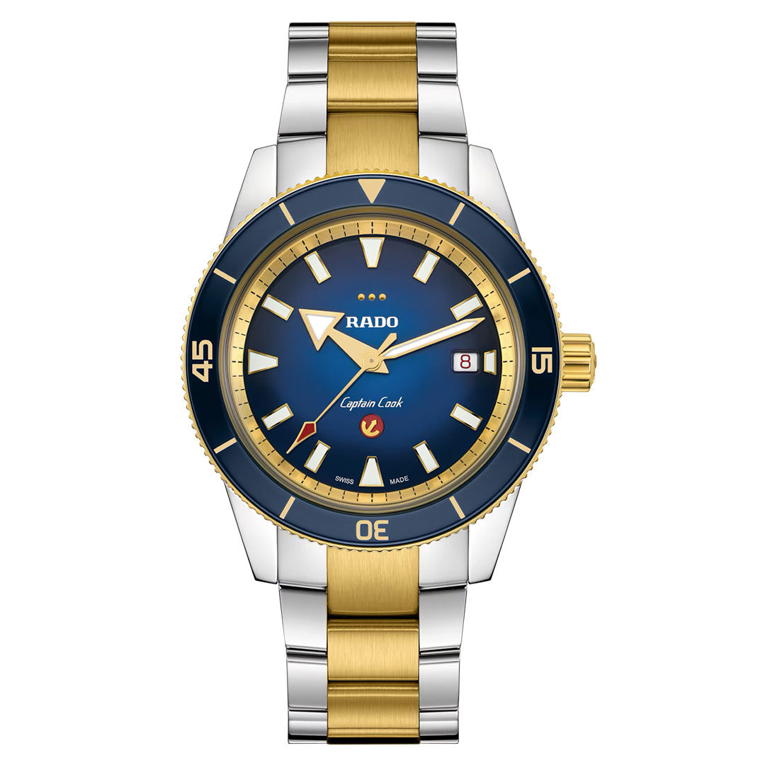 The RADO Captain Cook X European Cricket Special Edition Automatic 42mm Watch features a gold and silver metal band, blue dial with gold accents, date display, and a gold-tone bezel, showcasing reliable automatic movement for precision timekeeping.