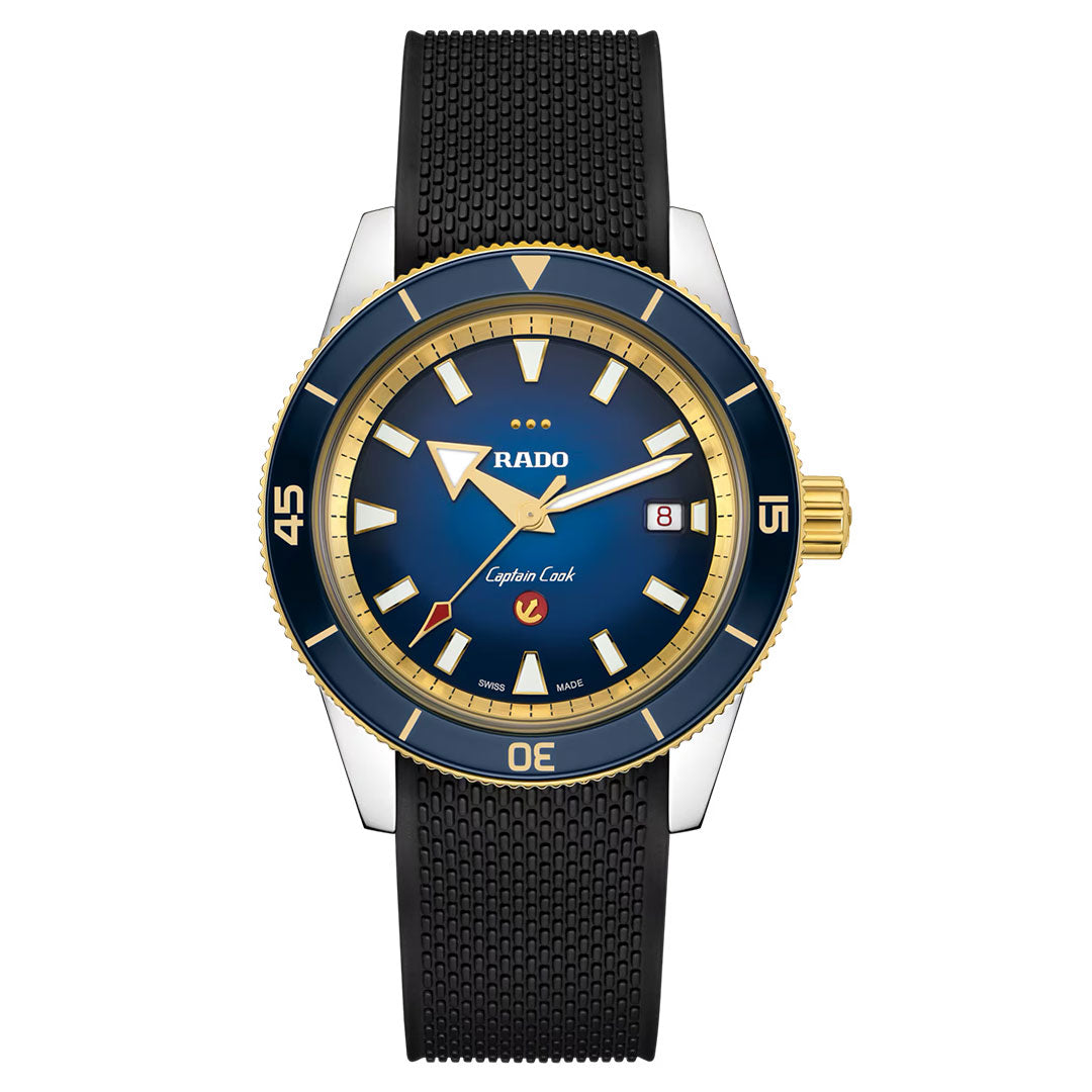 Introducing the RADO Captain Cook X European Cricket Special Edition Automatic 42mm Watch: an automatic timepiece featuring a striking blue and gold bezel, blue dial with gold markers, black textured strap, and a date display at 3 o’clock.