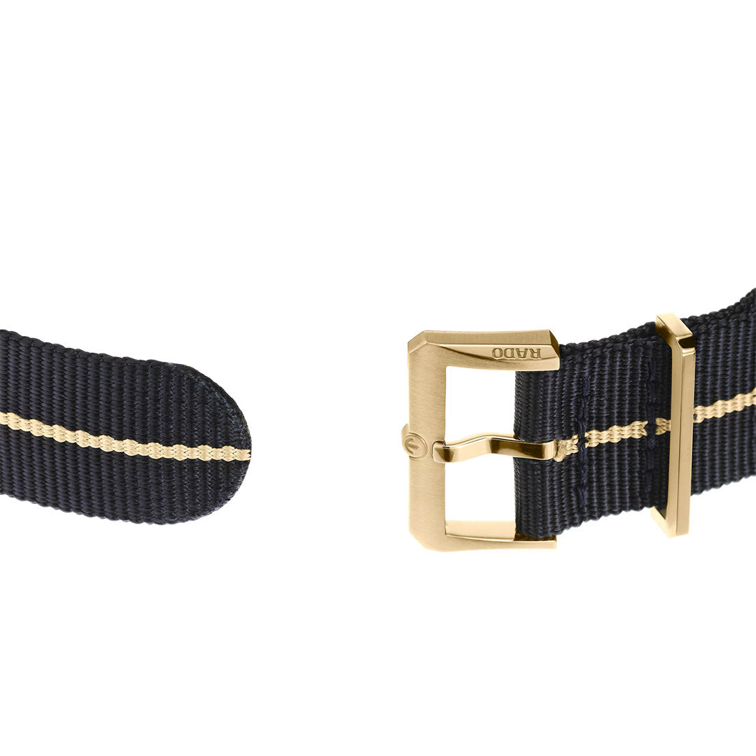 Navy blue fabric watch strap featuring a gold buckle and a thin yellow stripe down the center, displayed against a white background—an ideal accessory to complement your RADO Captain Cook X European Cricket Special Edition Automatic 42mm Watch.