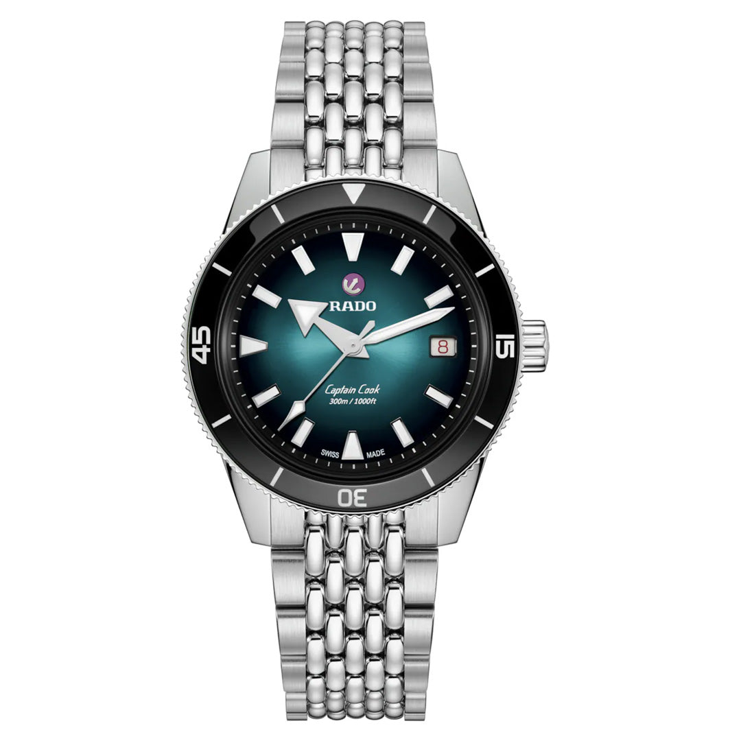 The RADO Captain Cook Automatic 39mm Watch by RADO features a stainless steel case, teal gradient dial, silver hour markers, date at 3 o’clock, bold white hands, and a robust bracelet. Water-resistant to 300m for durability.