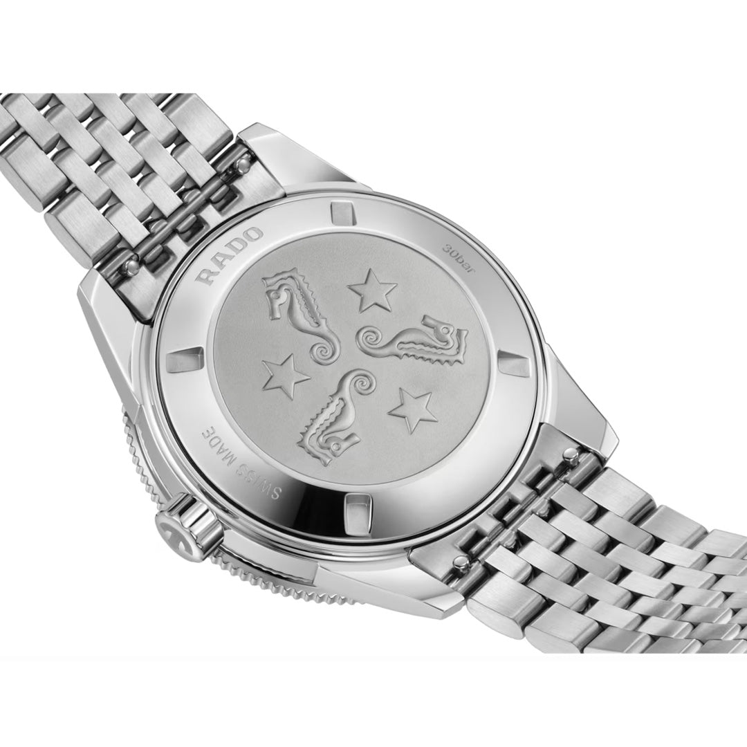 The RADO Captain Cook Automatic 39mm Watch features an engraved stainless steel caseback with three seahorses, two stars, and a metal link bracelet. “RADO” and “SWISS MADE” are inscribed to mark this Swiss-made timepiece.