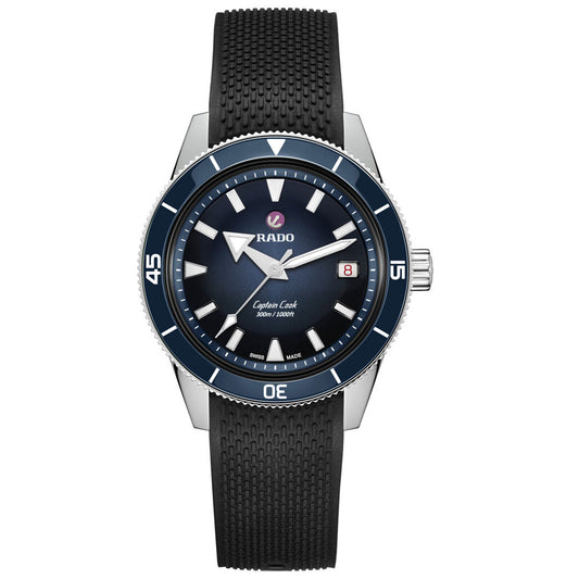 The RADO Captain Cook Automatic 39mm Watch features a black textured strap, blue ceramic bezel, and blue gradient dial with bold luminous markers and hands. The date display sits at 3 o’clock for easy readability.