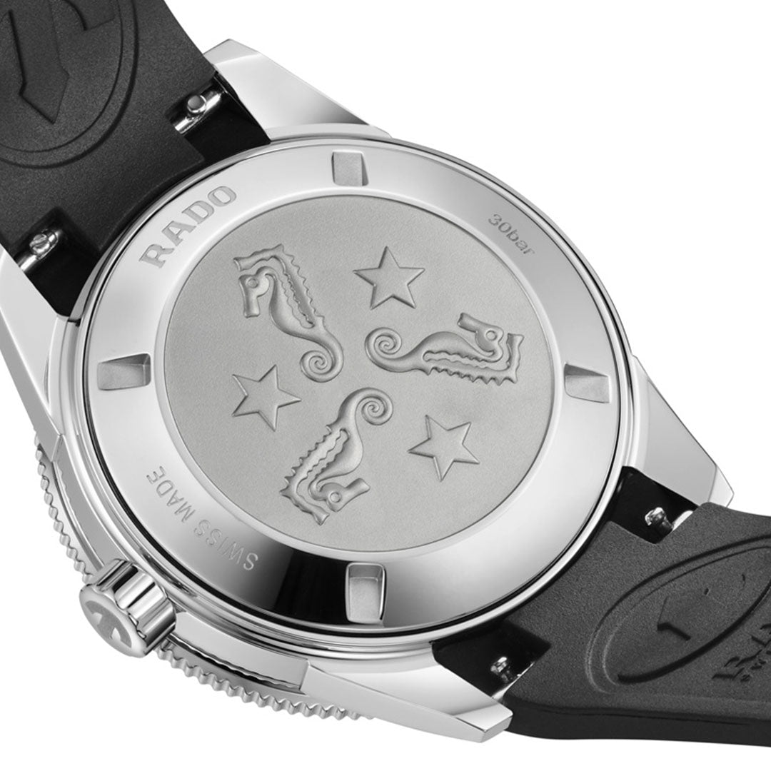 The RADO Captain Cook Automatic 39mm Watch showcases engraved seahorses and stars on its caseback, framed by a stainless steel case, ceramic bezel, and completed with a black rubber strap.