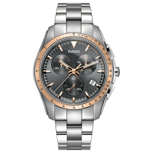 The RADO HyperChrome Chronograph Quartz 44.9mm Watch is an energetic timepiece, designed with a round stainless steel face featuring a grey background, three subdials, and a date display. It highlights a rose gold bezel and silver bracelet strap, proudly displaying the RADO brand on its sporty design.