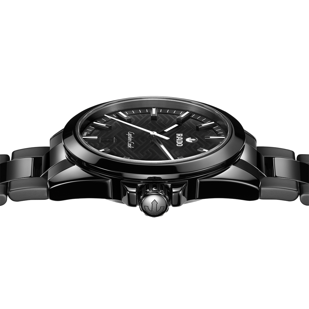 RADO Captain Cook Discover Automatic 40.7mm Watch with a patterned black dial, silver hands and markers, and a black link bracelet.