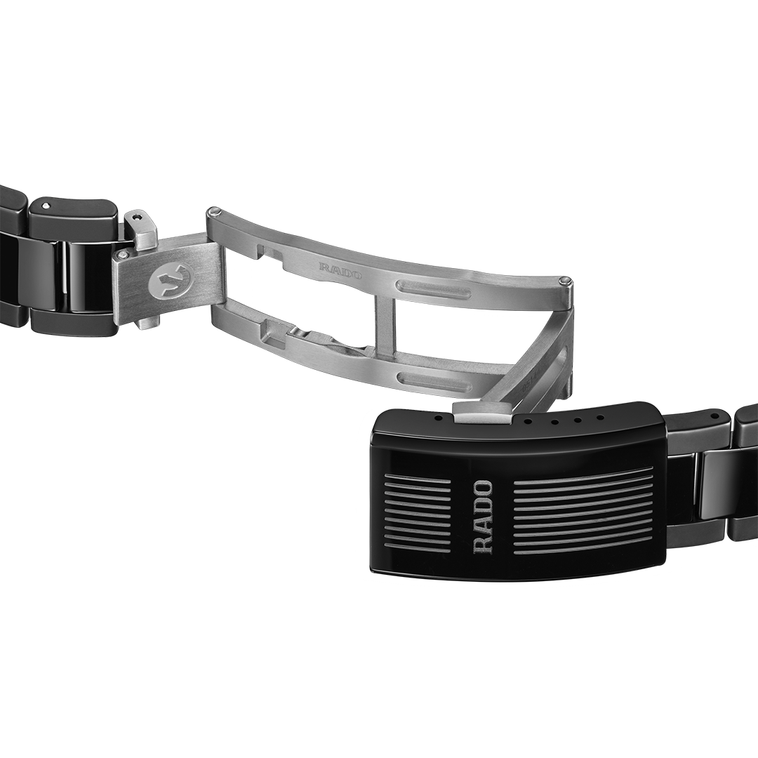The partially open metal deployment clasp of a RADO Captain Cook Discover Automatic 40.7mm Watch, showing the internal hinges and black high-tech ceramic links.