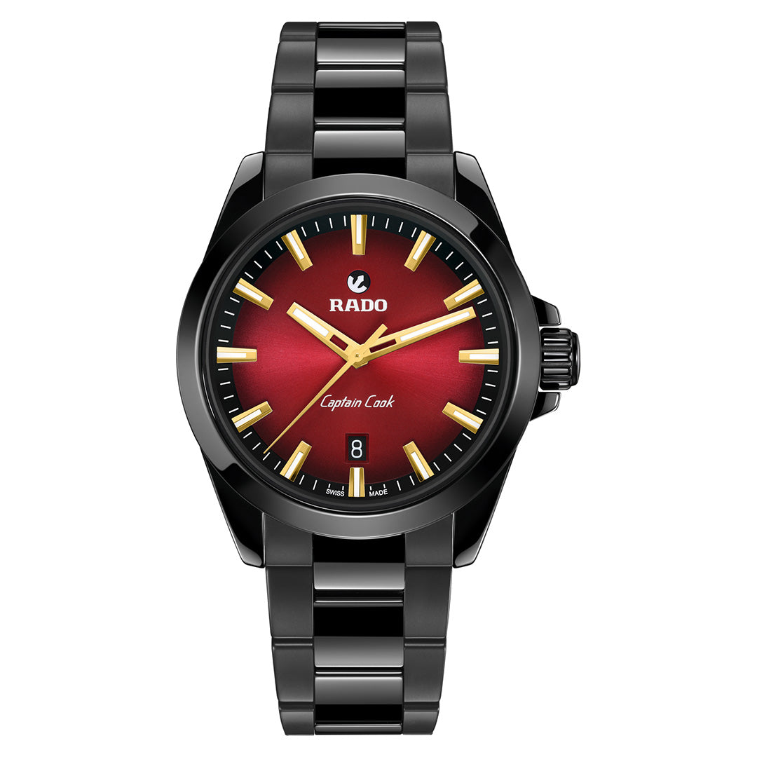 The RADO Captain Cook Discover Automatic 40.7mm Watch features a black metal band, red gradient dial, gold hour markers and hands, 80-hour power reserve, and date display at 6 o’clock.