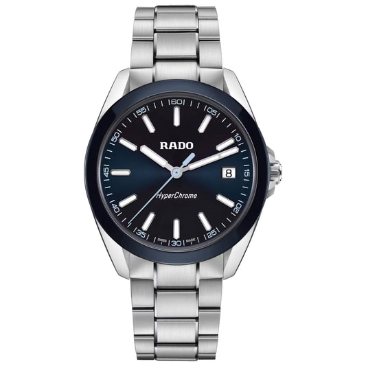 The RADO HyperChrome Quartz 41.5mm Watch by RADO features a blue dial, silver markers and hands, date at 3 o’clock, high-tech ceramic bezel, and a stainless steel bracelet; shown on a white background.