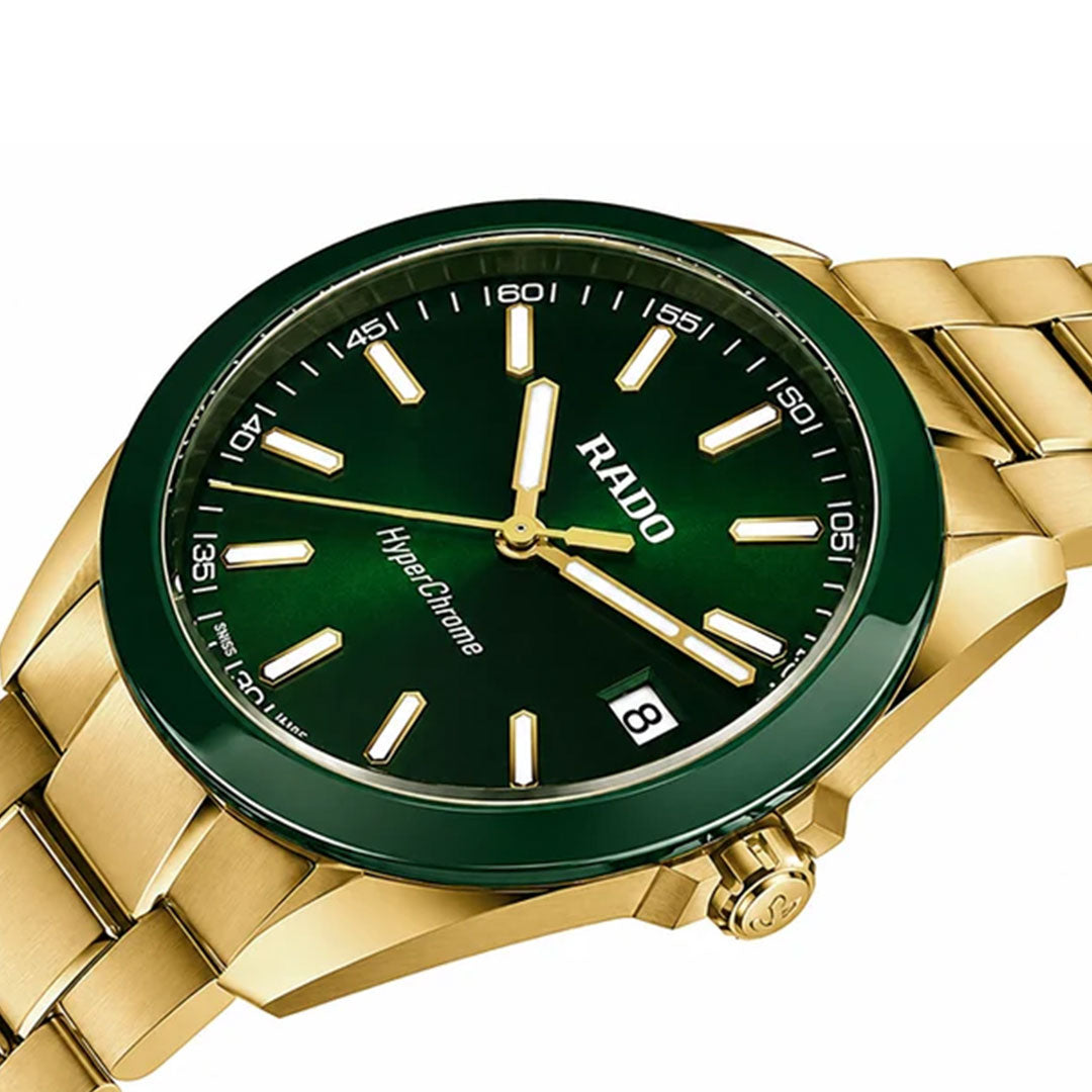 The RADO HyperChrome Quartz 41.5mm Watch features a gold case, metallic green dial with white markers and hands, green ceramic bezel, date window at 3 o'clock, gold bracelet, and is powered by the Rado calibre R292.