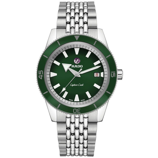 The RADO Captain Cook Automatic 42mm Watch, created by RADO, showcases a vintage design with a silver five-link metal bracelet. It features a striking green dial adorned with white hour markers and includes a date display at the 3 o'clock position, seamlessly combining timeless style with modern elegance.