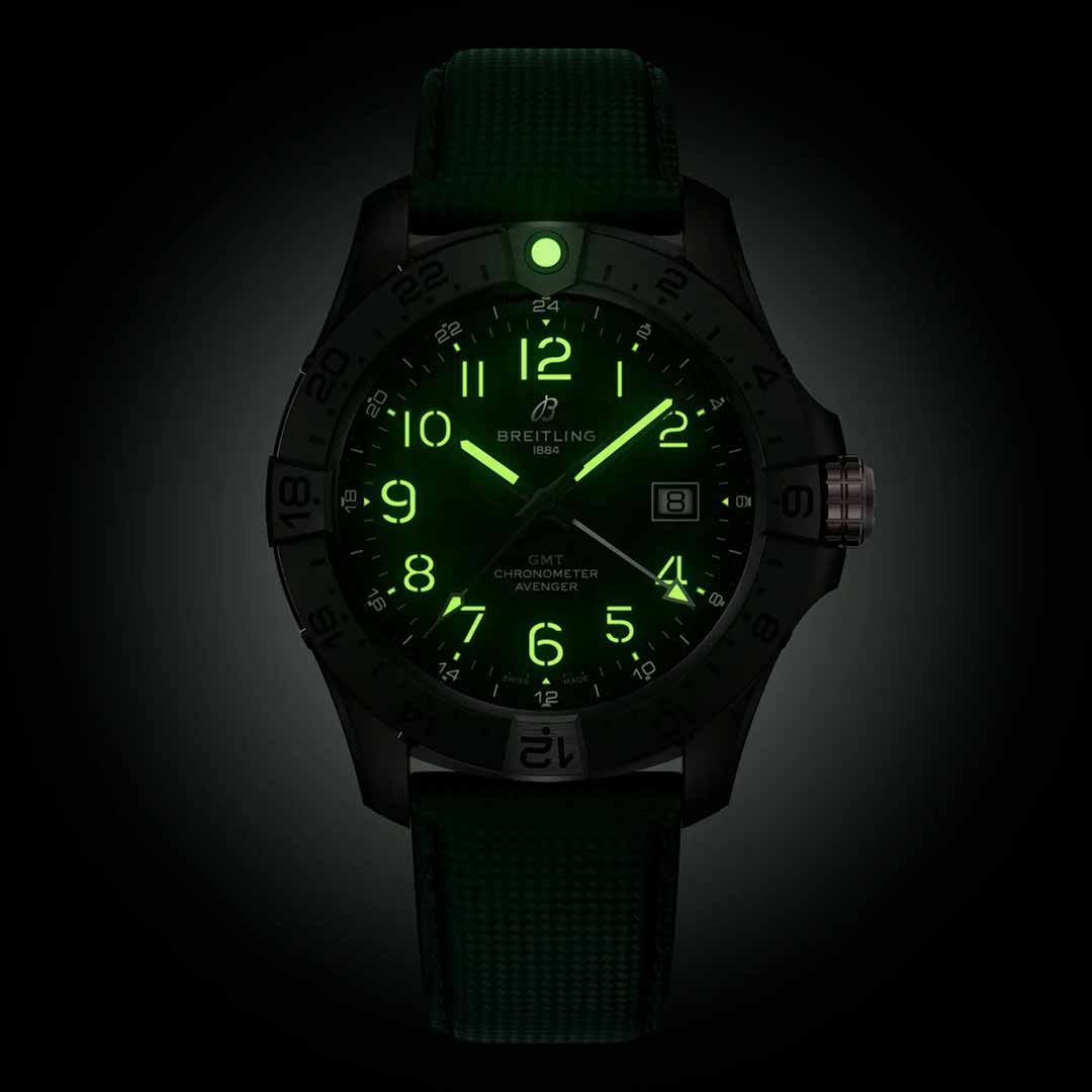 The BREITLING Avenger Automatic GMT 44 Night Mission, inspired by aviation style, offers green glowing numerals and hands for easy visibility in the dark. It includes a date window, a durable strap, water resistance, an illuminated bezel, and a bold design suitable for various environments.