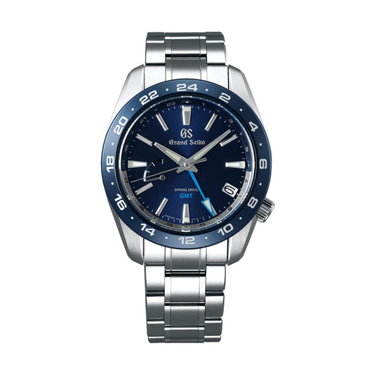 The Grand Seiko Sport Collection Spring Drive GMT 40.5mm Watch features a blue dial and stainless steel bracelet, complete with a 24-hour bezel, silver hour markers, and hands. A date window at 4 o'clock enhances the design, accompanied by the prominent "Grand Seiko" branding and "Spring Drive" label.