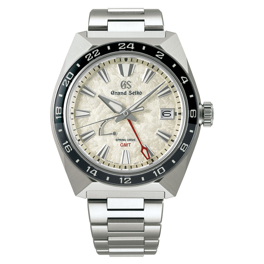 The Grand Seiko Sport Collection Spring Drive 44.5mm Watch showcases a textured white dial with a black and white bezel, alongside a bold red GMT hand. Its stainless steel bracelet enhances the timepiece's design, featuring both 12-hour and 24-hour markers and proudly displaying the "Spring Drive" label on the dial.