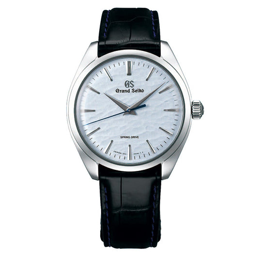 This Grand Seiko Elegance Collection Omiwatari Manual Winding Spring Drive 3-day Power Reserve 38.5mm watch features a stainless steel case, white dial, and black crocodile leather strap. It includes slender silver hour markers and hands, with "Grand Seiko" and "Spring Drive" inscribed on the dial.