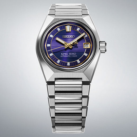 The Seiko King Seiko VANAC Automatic with Manual Winding 41mm watch features a blue dial with gold accents, date window at 3 o'clock, and a silver metal band, displayed against a light gray background.