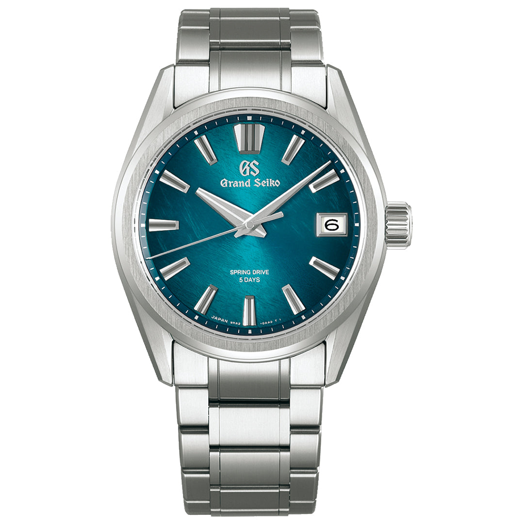 The Grand Seiko Evolution 9 Collection Spring Drive 40mm watch features a silver case with a teal dial, silver hour markers, and hands. It runs on the Caliber 9RA2 Spring Drive movement with a date window at 3 o'clock and "Spring Drive, 5 Days" above 6 o'clock. An elegant metal bracelet enhances its timeless design.