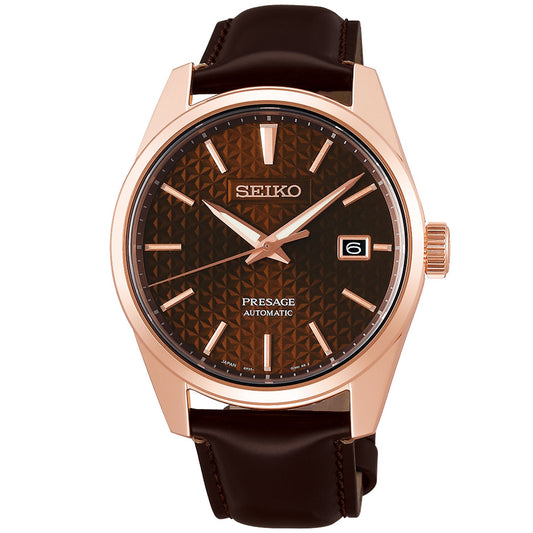 Introducing the Seiko Presage Prestige Line Automatic with Manual Winding 39.3mm Watch, featuring a striking dark brown patterned dial within a rose gold-tone case. It is complemented by a black leather strap. Driven by Caliber 6R35, this timepiece boasts an impressive 70-hour power reserve and includes a date window at the 3 o'clock position. Rose gold-tone hands and hour markers enhance its elegance, while offering water resistance up to 10 bar.