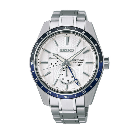 This Seiko Presage Prestige Line Sharp Edge Series Zero Halliburton Limited Edition features a sophisticated mechanical design with a stainless steel body, enhanced by a silver bracelet and a white textured dial. The watch is accented with a striking blue-silver bezel, while its small subdial accentuates the classic Japanese aesthetic. The face prominently displays "SEIKO PRESAGE AUTOMATIC GMT.