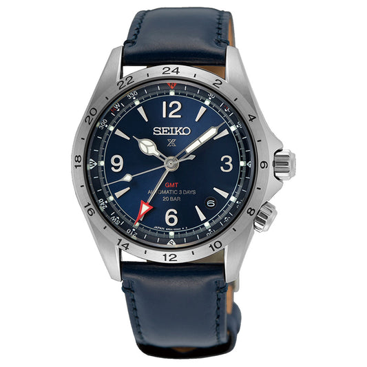 The Seiko Prospex Land Automatic With Manual Winding 39.5mm Watch by Seiko comes with a blue leather strap and a silver case. It features a dark blue dial with white numerals, luminescent hands, a red GMT hand, the Caliber 6R54 inscription, and the text "GMT Automatic 3 Days 20 BAR." The bezel is designed with a 24-hour scale.