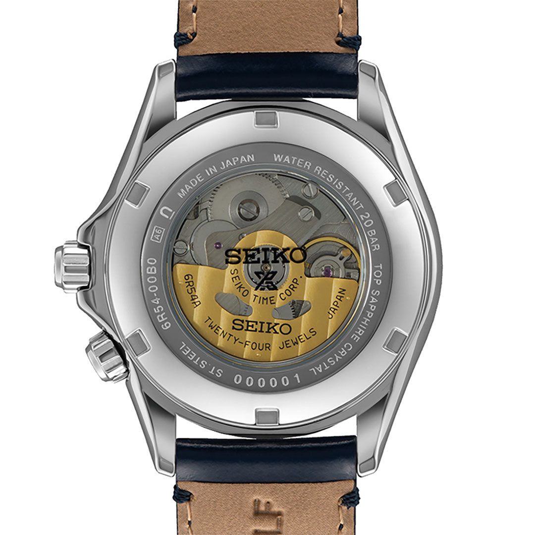 The image showcases the Seiko Prospex Land Automatic With Manual Winding 39.5mm Watch, featuring a transparent case back that reveals its inner mechanical movement. Crafted by Seiko, this timepiece combines elegance and functionality with its stainless steel body and brown leather strap, highlighted by engraved text on the back.