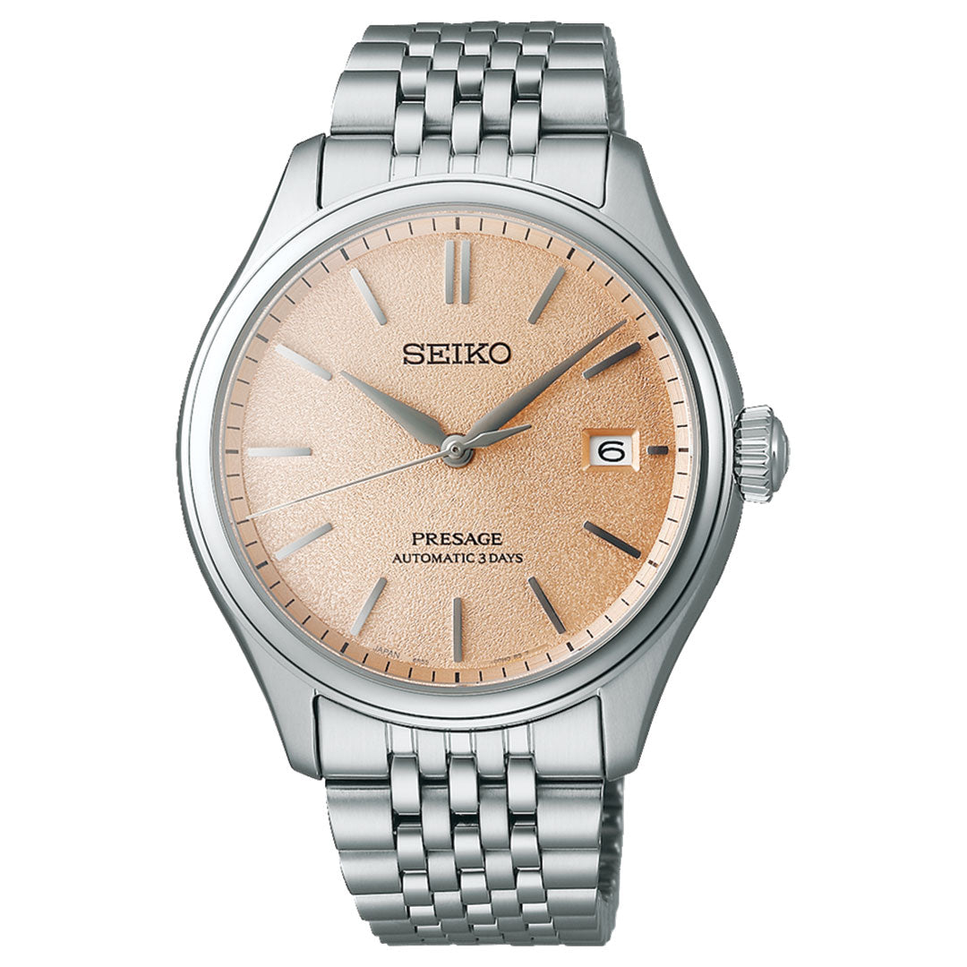 The Seiko Presage Classic Series Automatic With Manual Winding 40.2mm Watch features a sophisticated stainless steel bracelet and case, beautifully complementing its textured rose gold dial. It is elegantly adorned with slim silver hour markers and hands, includes a date window at 3 o'clock, and prominently displays the "Automatic 3 Days" text, emphasizing its automatic movement capabilities.