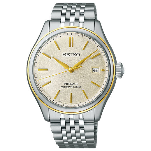 The Seiko Presage Classic Series Automatic with Manual Winding 40.2mm Watch features a silver and gold-tone case, light beige textured dial, gold hands and markers, date at 3 o'clock, and a silver metal link bracelet.