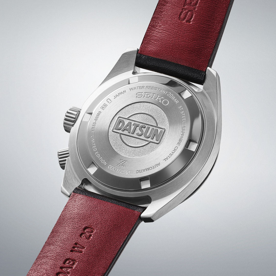The back of a Seiko Prospex Speedtimer Datsun 240Z Automatic 39.5mm Limited Edition watch, featuring "DATSUN" engraving, brown leather straps, and metal detailing on a plain light background. Limited to 2500 pieces.